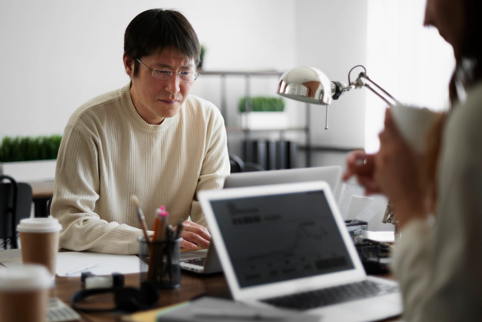 屋外で印刷した資料を一緒に確認するビジネスウェア姿の男女